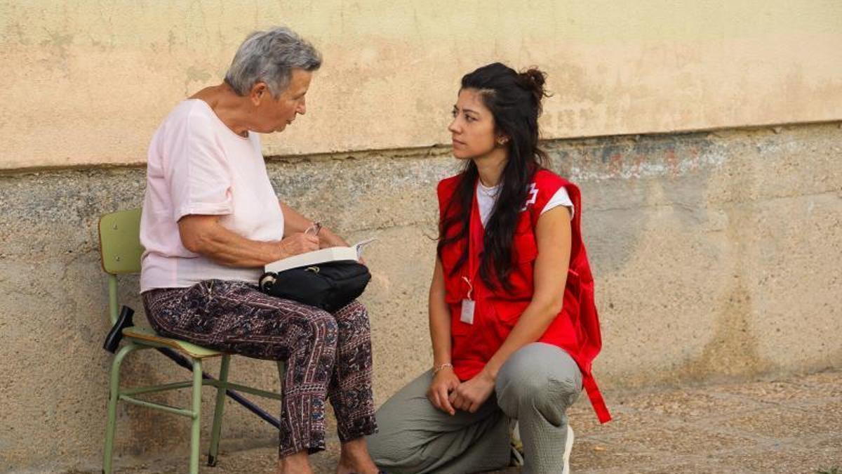 Una técnico de Cruz Roja escucha a una de las vecinas evacuadas a Bermillo.