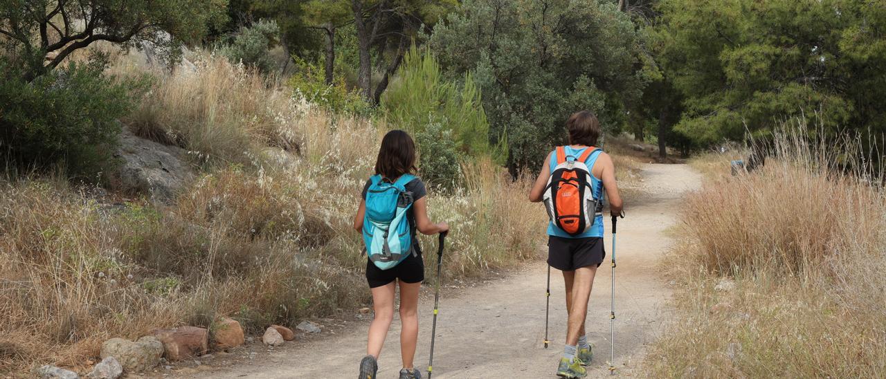 Dos senderistas por un camino del Desert de les Palmes, en fotografía de archivo.