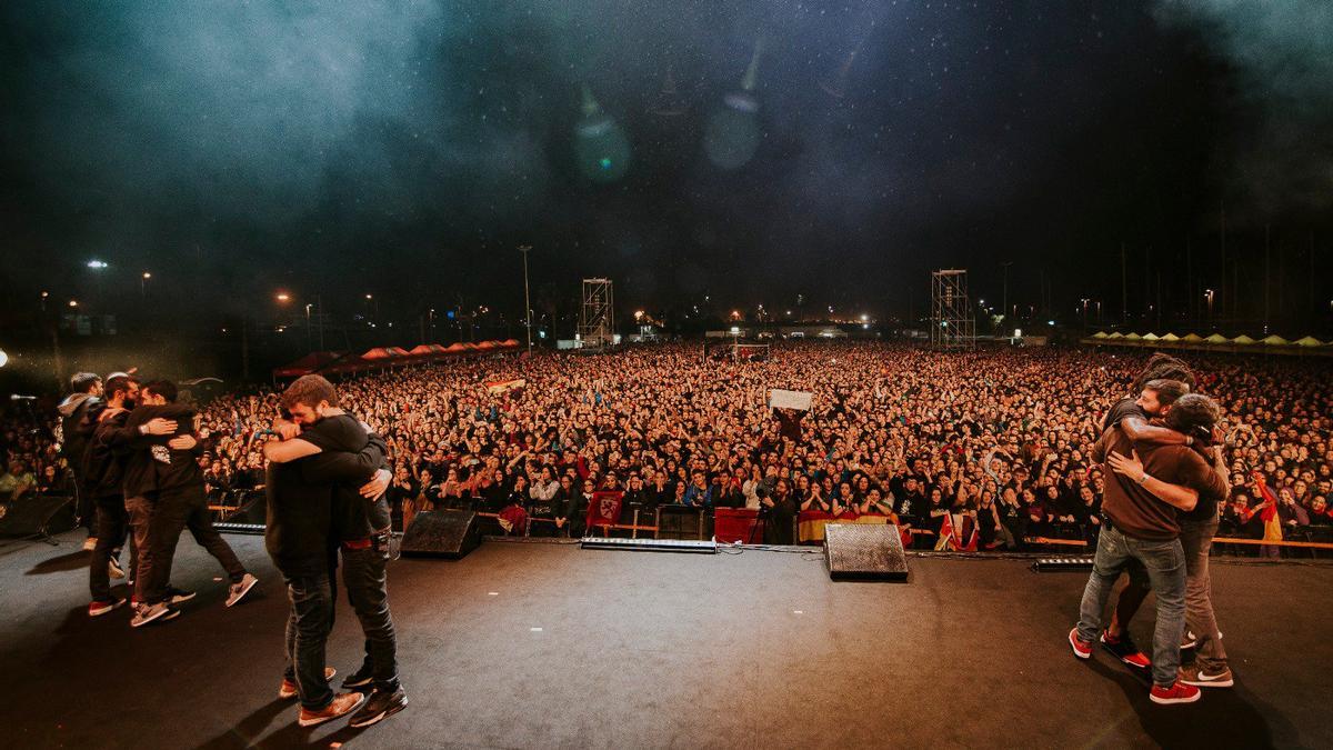 Miembros de La Raíz se abrazan tras el último concierto en 2018.