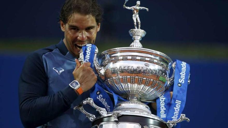 Rafa Nadal muerde el trofeo del Conde de Godó, que conquistó ayer en Barcelona. // Albert Gea