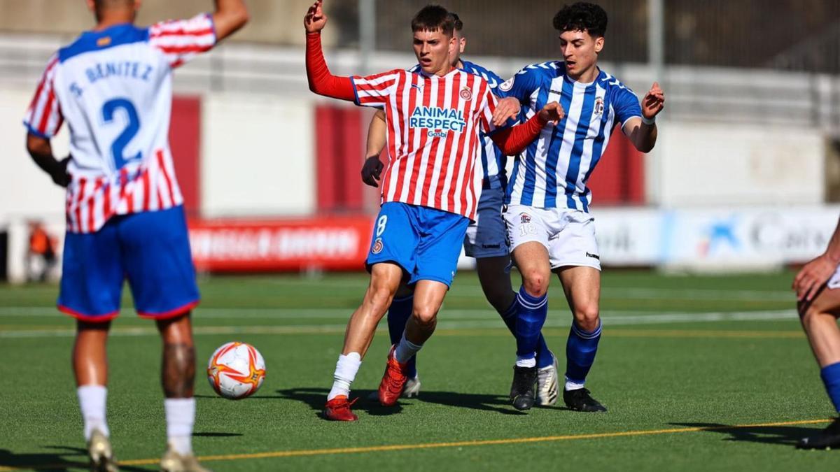 Àlex Sala defensant una pilota davant dos jugadors del San Cristóbal, ahir a Rubí. | FEDERACIÓ CATALANA DE FUTBOL