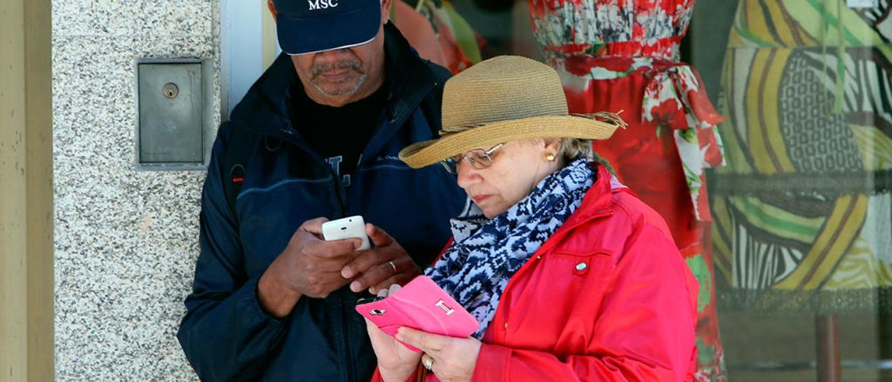 Turistas en Vigo consultan el móvil en Príncipe // Marta G. Brea