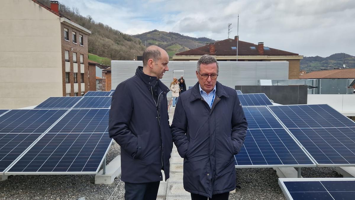 Pablo García, a la izquierda, y José Antonio Vecino, en la azotea del edificio, con las placas solares