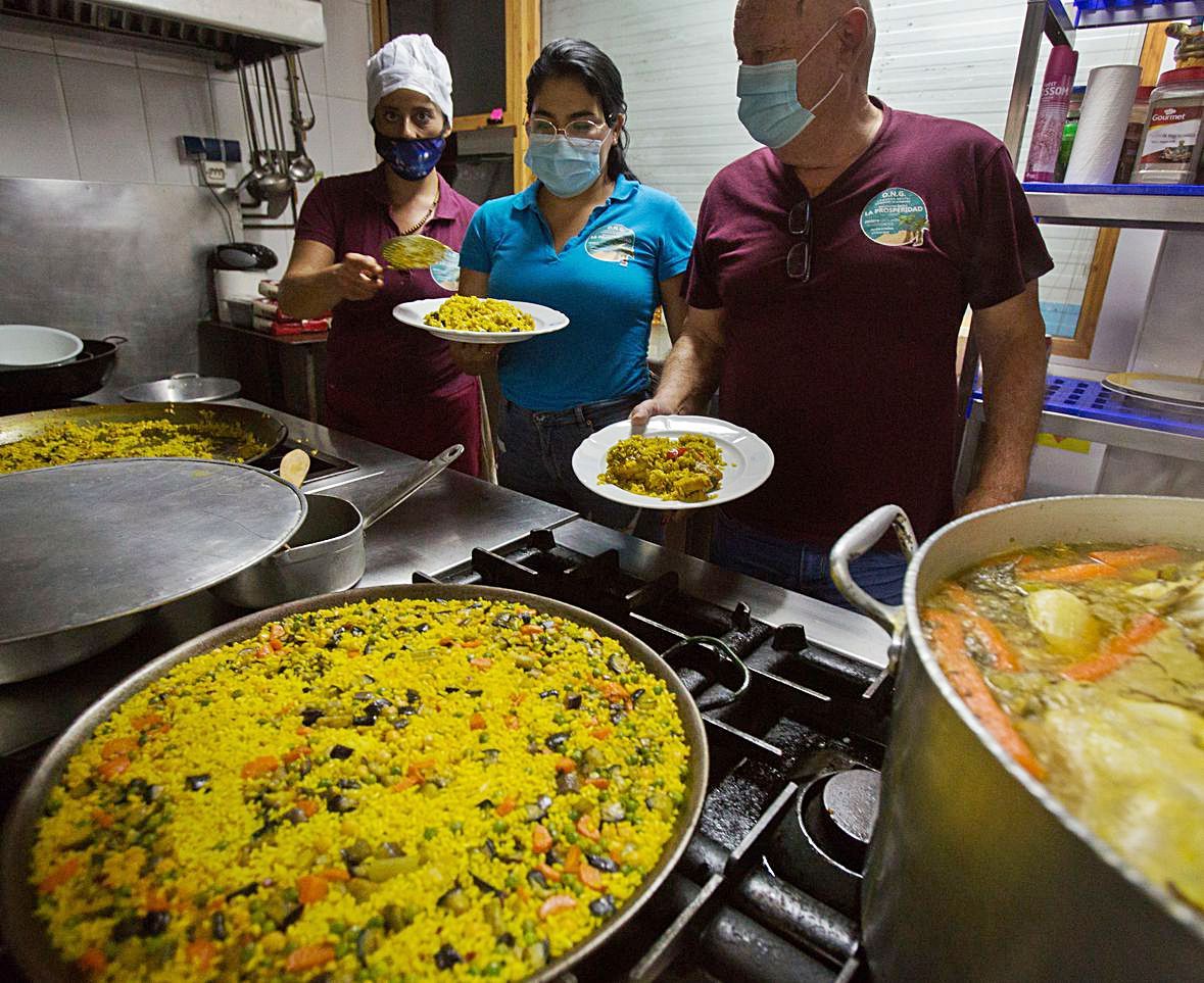 Voluntarios del comedor social de San Gabriel cocinan varios platos y, a la derecha. | JOSE NAVARRO/INFORMACIÓN