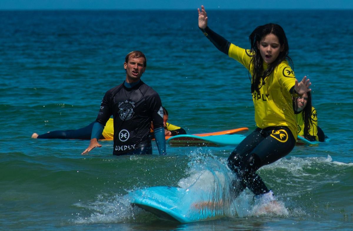 Una alumna toma una ola durante un entrenamiento, esta semana en la playa del Orzán.  | // CASTELEIRO/ROLLER AGENCIA