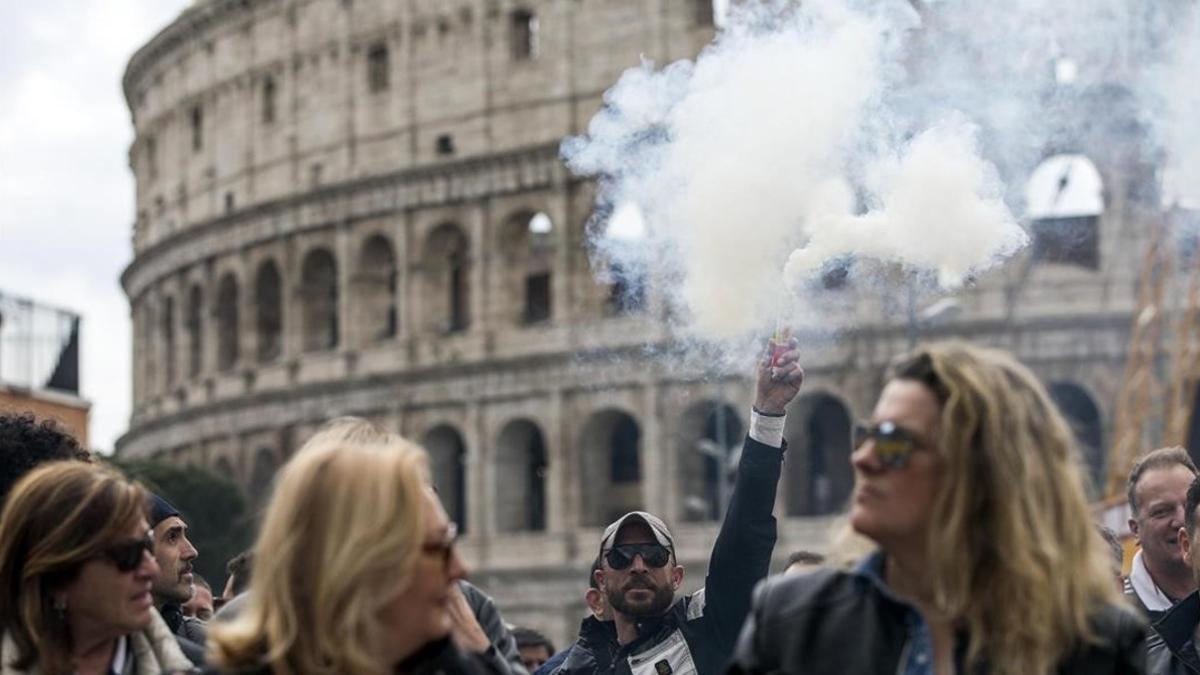 Un hombre alza una lata de humo durante una protesta frente al Coliseo de Roma  Italia   durante una huelga convocada hoy  23 de marzo de 2017  tras la reunion de ayer entre taxistas y Gobierno en la que no se llego a un acuerdo.