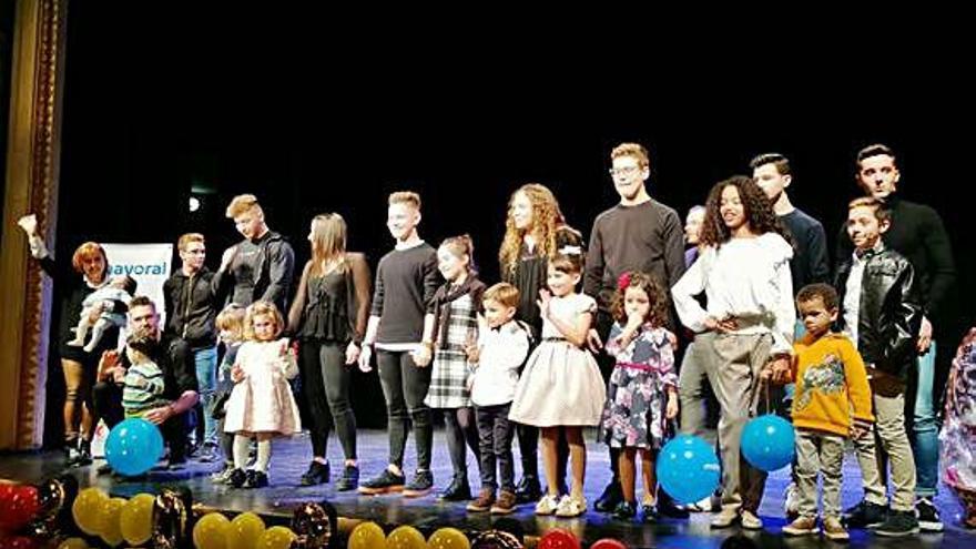 Jóvenes acompañados por primos y hermanos posan tras el desfile de moda infantil.