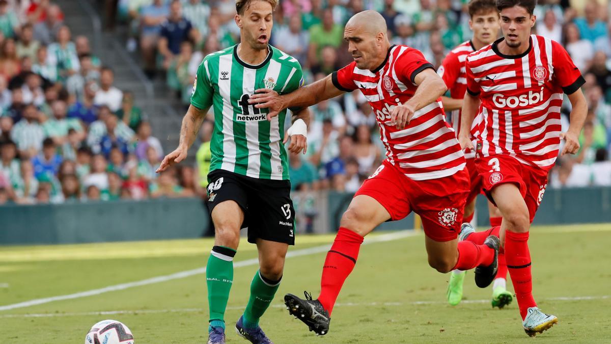 Oriol Romeu intenta frenar a Sergio Canales en el Betis-Girona del Benito Villamarín.