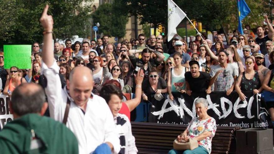 Un aficionado taurino dedica una peineta a los manifestantes antitaurinos que le increpan a la entrada de la plaza.