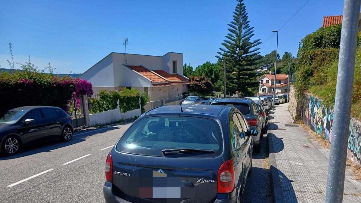 Coches aparcados, este julio, en el entorno de la playa de Menduíña, en Aldán.