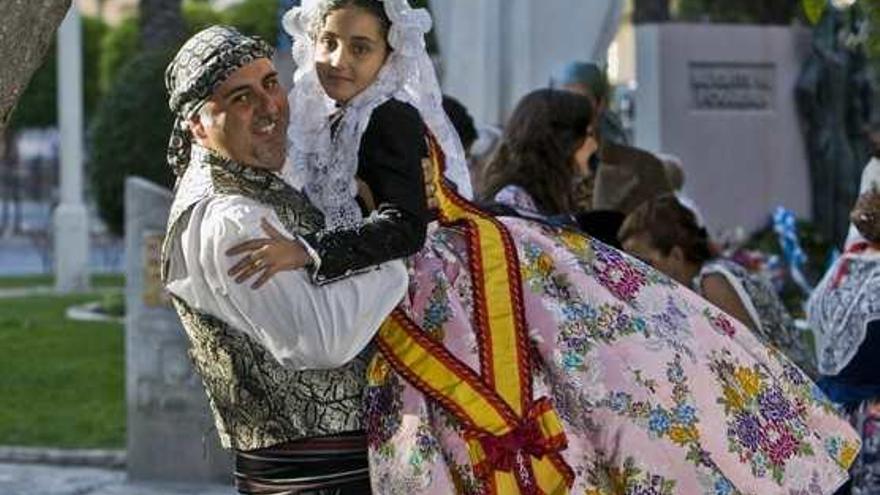 Manuel Jiménez levanta en brazos a su hija Triana durante uno de los actos de estas fiestas.