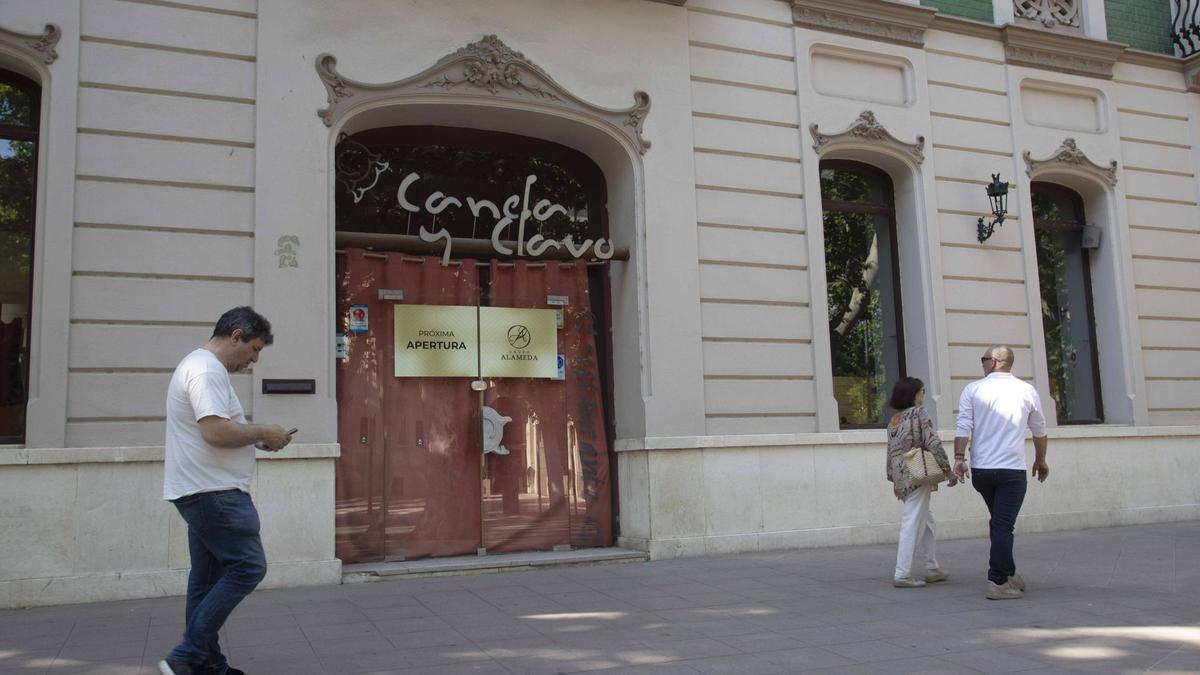 Tres personas pasan por delante de la fachada del local de l'Albereda de Xàtiva que reabrirá el grupo Alameda.