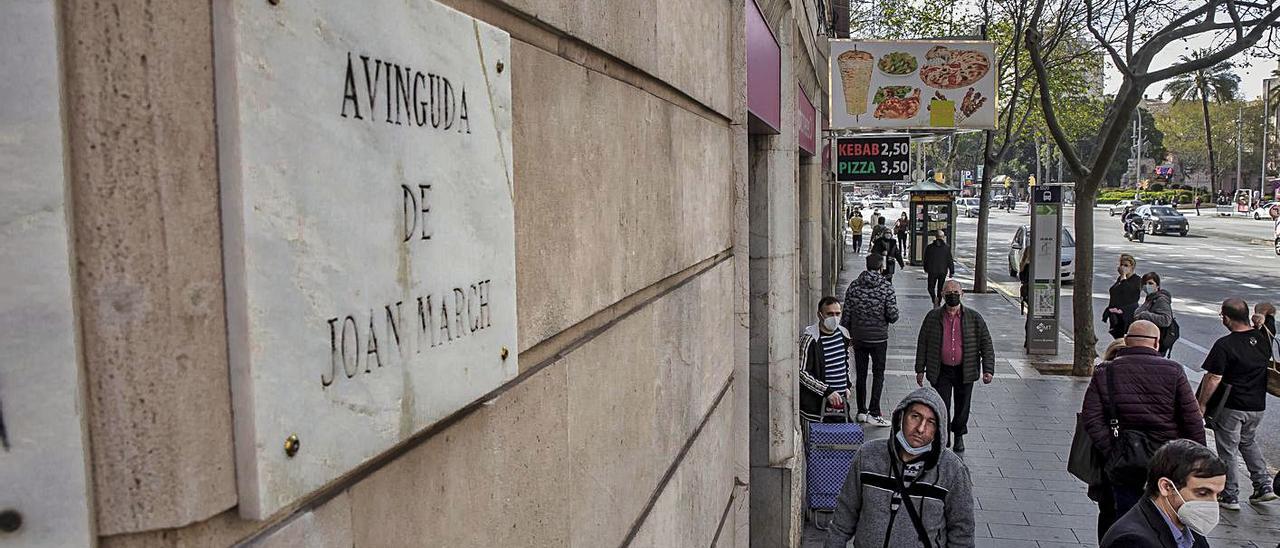 Un hombre mira la placa de Joan March antes de ser cambiada.