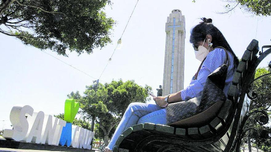 Una mujer con mascarilla, sentada ayer en un banco de la Plaza de España.