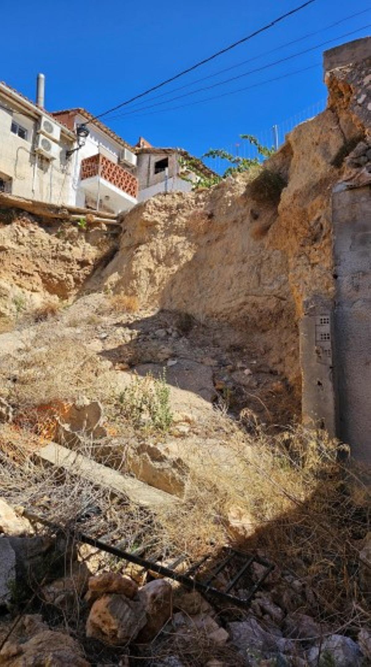 Talud desmoronado y escombros de la vivienda demolida en Navarrés.