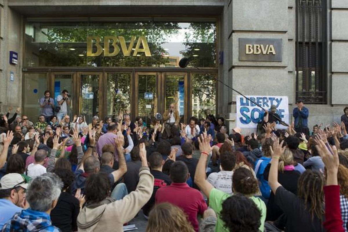 Davant el BBVA, Arcadi Oliveres va fer una conferència als integrants del 15-M en la jornada de manifestació després d’un any de l’acampada a la plaça de Catalunya