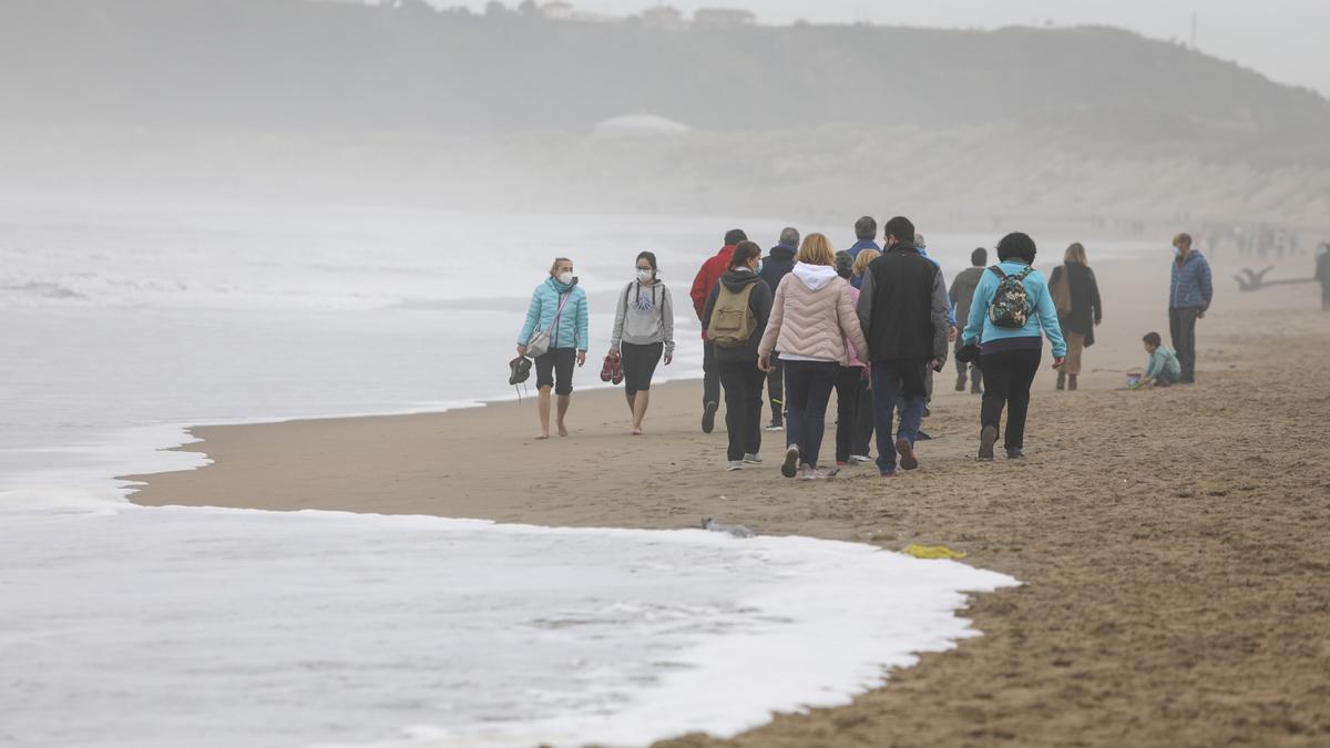 Personas paseando, ayer, por la playa de Salinas.
