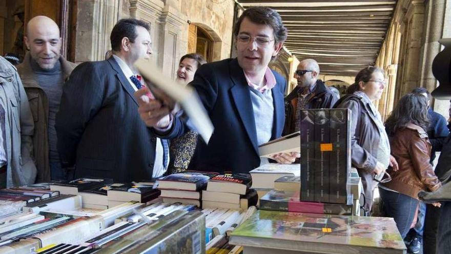 El alcalde de Salamanca, Alfonso Fernández Mañueco, coge un ejemplar en la Feria del Libro.