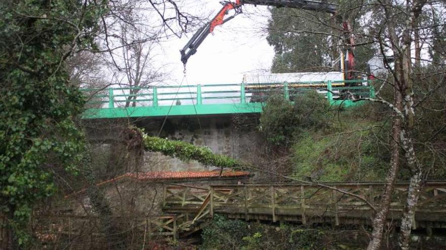 La grúa retira, ayer, el tronco caído en el paseo fluvial del río Anllóns.