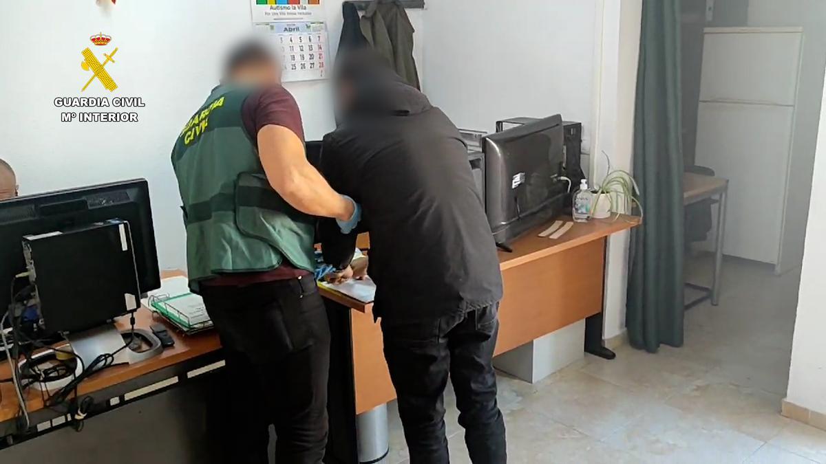 Imagen de un agente con uno de los detenidos en operación de la Guardia Civil.