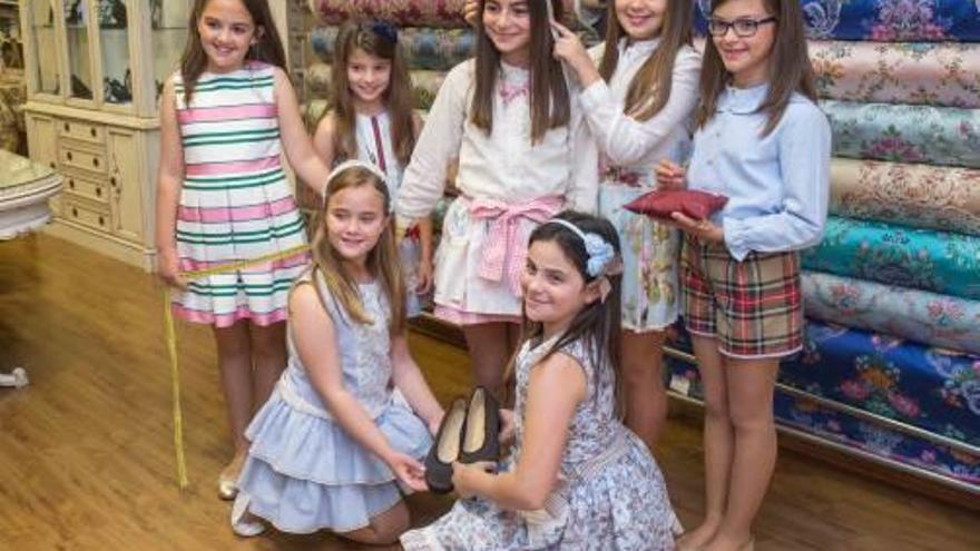 La indumentarista Ana Ballester toma medidas a la Bellea del Foc Infantil en presencia de sus damas. Al lado, las siete muestran los zapatos que lucirán.