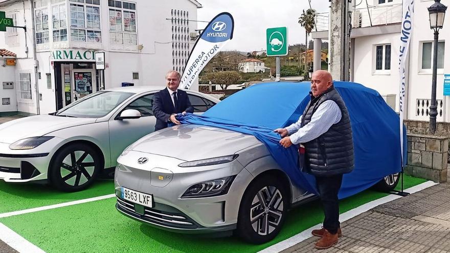 Santiso (derecha) y el gerente de Hypersa descubren, ayer, el coche que se podrá alquilar gratis. |   // I.R.