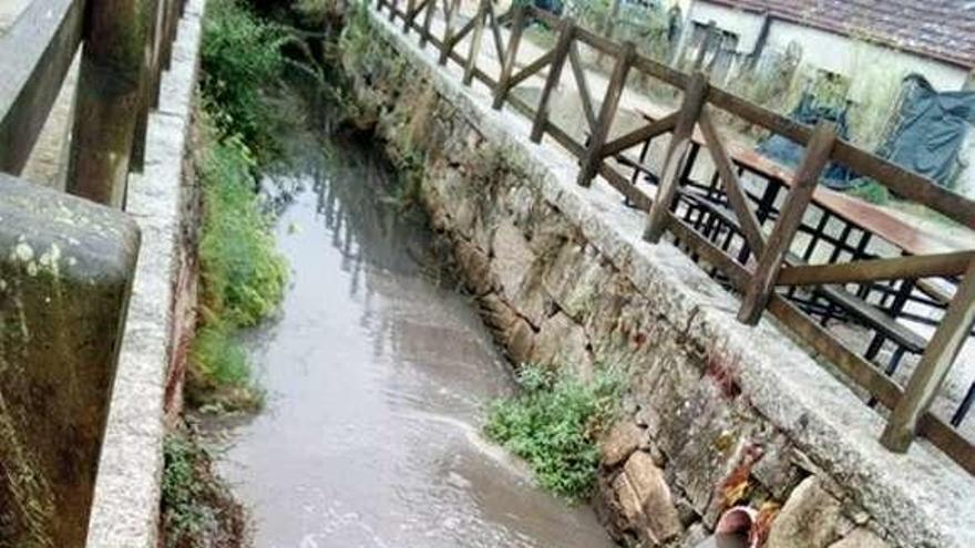 Aguas turbias cayendo, ayer, al cauce del río en Vilariño. // FdV