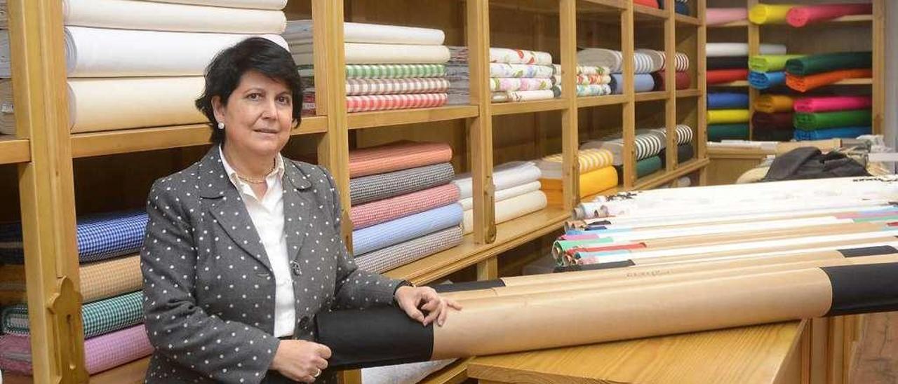 Mayte Ramírez coloca algunos rollos de tejidos en el interior de su nuevo negocio. // Rafa Vázquez
