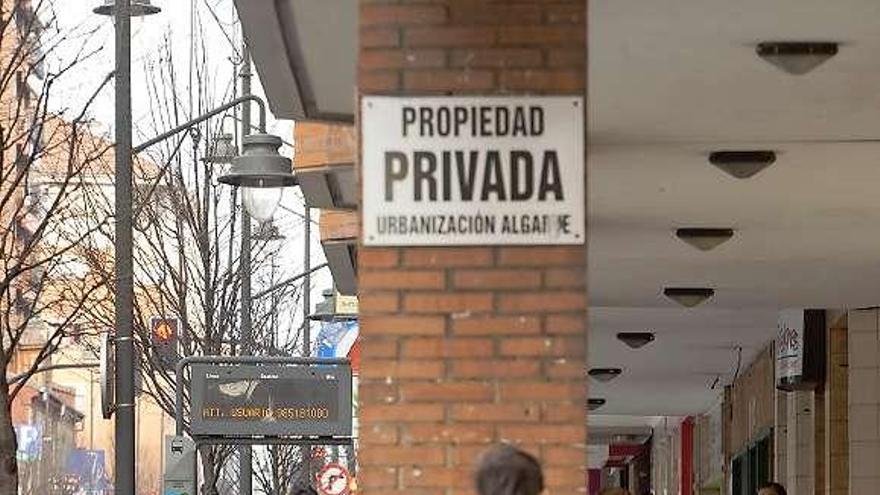 Paseantes en los soportales exteriores de la urbanización Algarve, que dan a la avenida de Galicia.