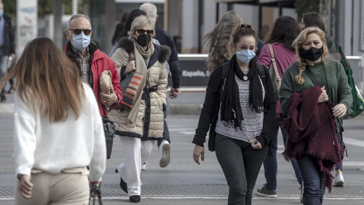 Personas caminando por la calle con mascarillas