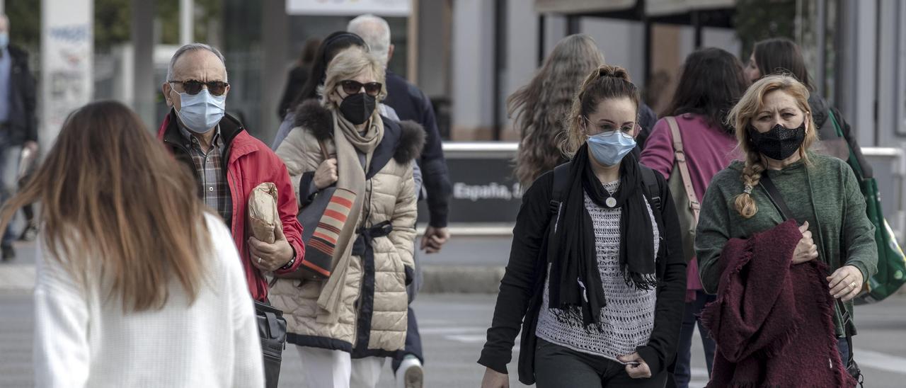 Personas caminando por la calle con mascarillas