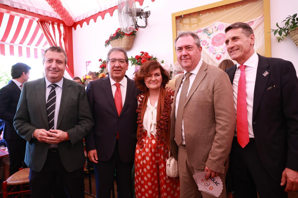 El presidente de la Fundación La Caixa , Antonio Pulido (2i) junto a la ex ministra, Carmen Calvo, (c) el presidente de la Diputación de Sevilla, Javier Fernández (i) el delegado del gobierno en Andalucía, Pedro Fernández (d) y el secretario general del PSOE A, Juan Espadas (2d) coinciden en la caseta de la fundación en el Real