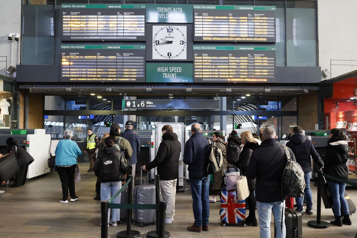 Numerosos pasajeros esperan en la estación sevillana de Santa Justa.