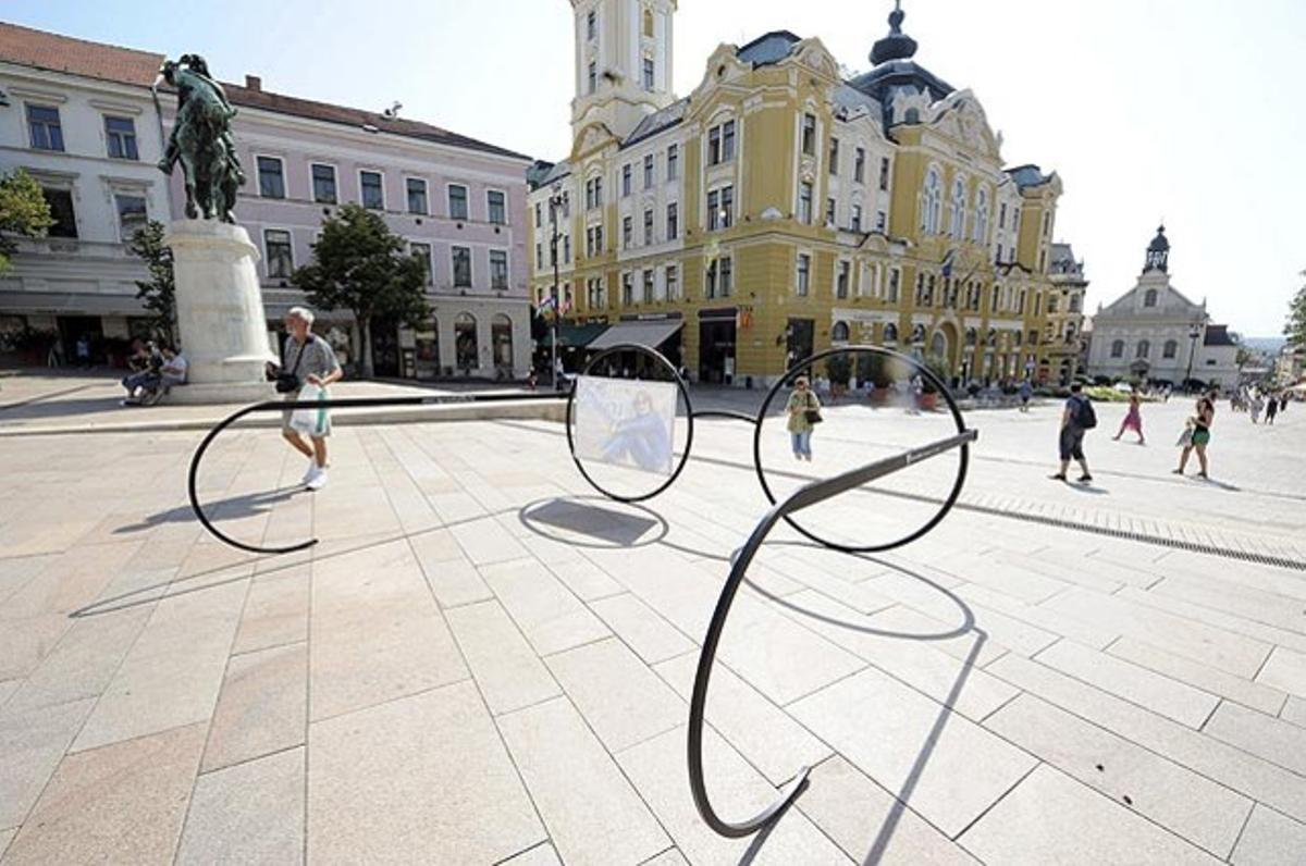 Els turistes passen a tocar d’una rèplica gegant de les ulleres del músic britànic John Lennon a la plaça Szechenyi, per promocionar l’exposició ’The Art of John Lennon’ a la Casa de les Arts a Pécs (Hongria). L’exposició alberga dotzenes d’objectes personals de l’artista de Liverpool, i estarà oberta al públic entre el 24 i el 26 de setembre.
