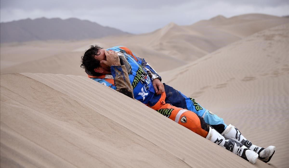 El piloto brasileño Marcos Colvero que participa en el Dakar con una moto, tirado en la arena después de estrellarse durante la Etapa 3 entre San Juan de Marcona y Arequipa, Perú.