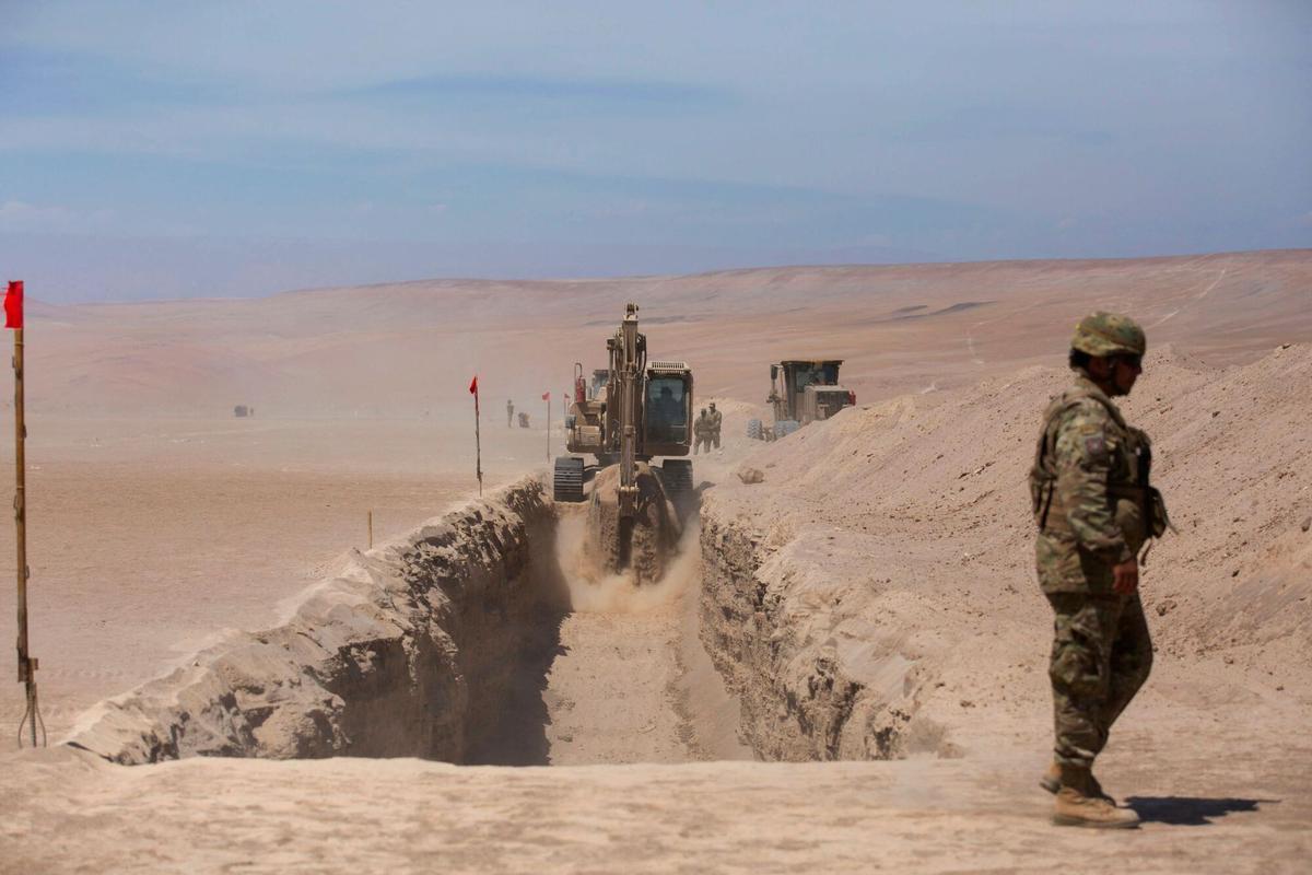 Excavadoras trabajan en la zanja para evitar la entrada de inmigrantes en la frontera de Chacalluta, entre Chile y Perú.