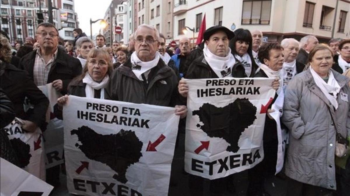 Don personas llevan carteles a favor de que los presos de ETA cumplan condena en Euskadi en una manifestación en Bilbao.