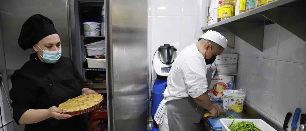 Dos cocineros trabajan en un establecimiento de hostelería.