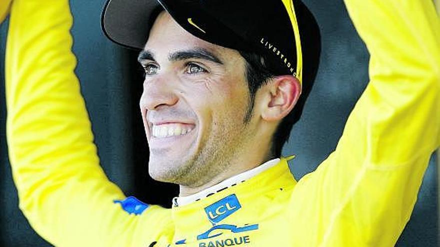 Alberto Contador, sonriente, en el podio con el maillot amarillo.