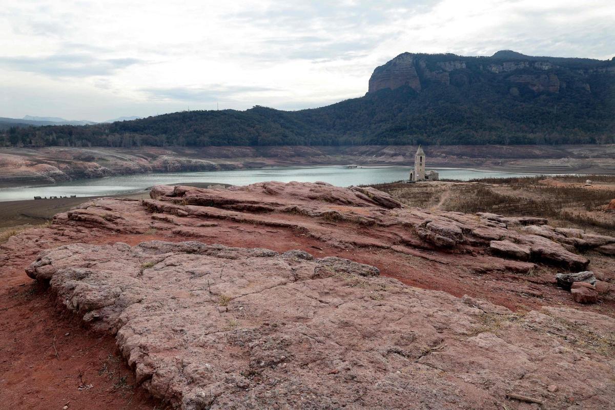 Esta fotografía tomada el 15 de enero de 2024 muestra el suelo seco junto al embalse de bajo nivel de Sau, en la provincia de Girona en Cataluña. Cataluña lucha contra una sequía histórica desde hace tres años y algunos residentes ya experimentan restricciones de agua en su vida diaria