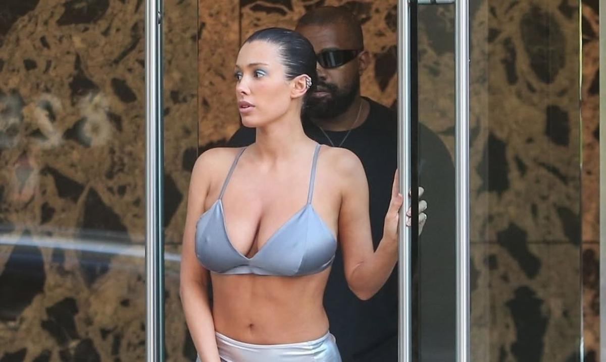 Bianca Censori y Kanye West salen de un edificio.