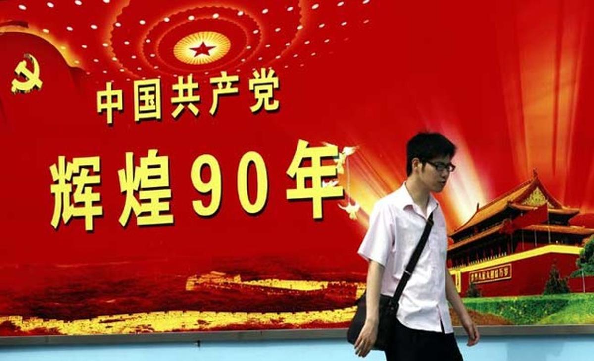 Un home passa al costat d’un cartell que anuncia el pròxim 90è aniversari de la fundació del Partit Comunista de Xina l’1 de juliol, a Xangai (Xina).