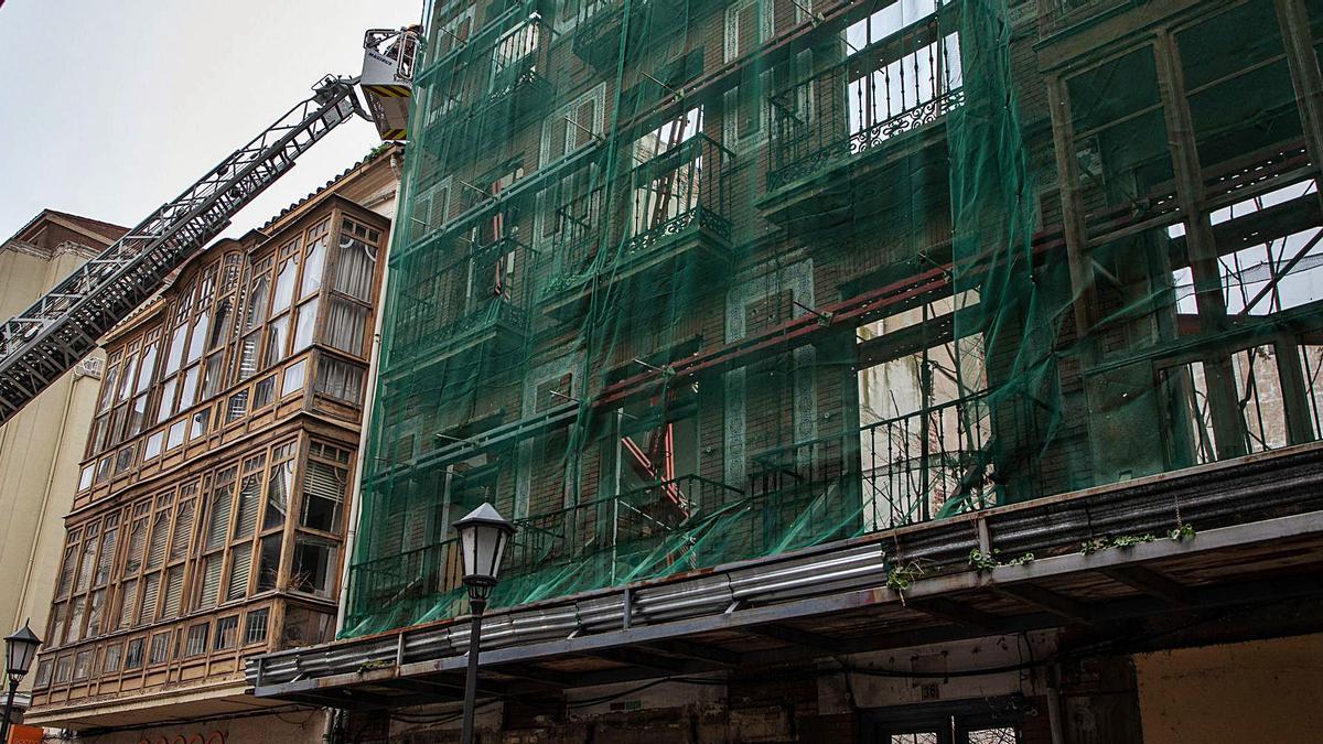 La arquiecta municipal inspecciona desde la escala de los Bomberos la estructrura de los dos inmuebles de la calle de San Torcuato y de Pelayo dañados. | Nico Rodríguez