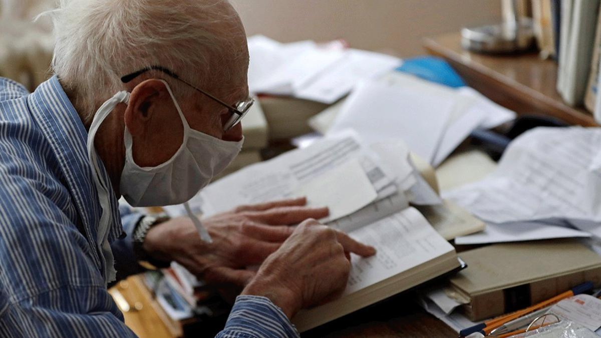 Petr Brandejsky, un superviviente del Holocausto de 90 años, lee un libro en su vivienda durante el confinamiento, en Praga el 24 de abril