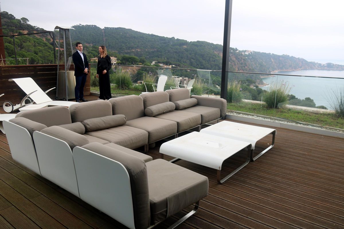 Els representants de la immobiliària BARNES a la terrassa d'una casa d'alt estànding en una urbanització de la Costa Brava