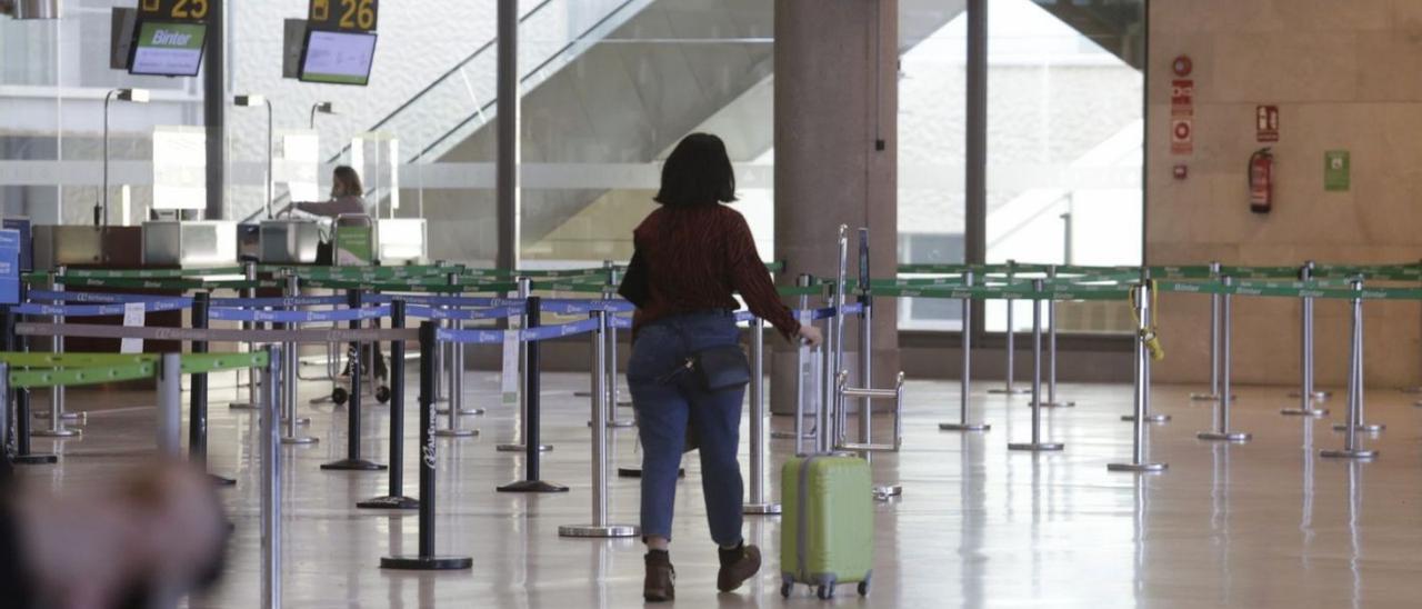 Una mujer arrastra su maleta en un semivacío aeropuerto Tenerife Norte-Los Rodeos. | |