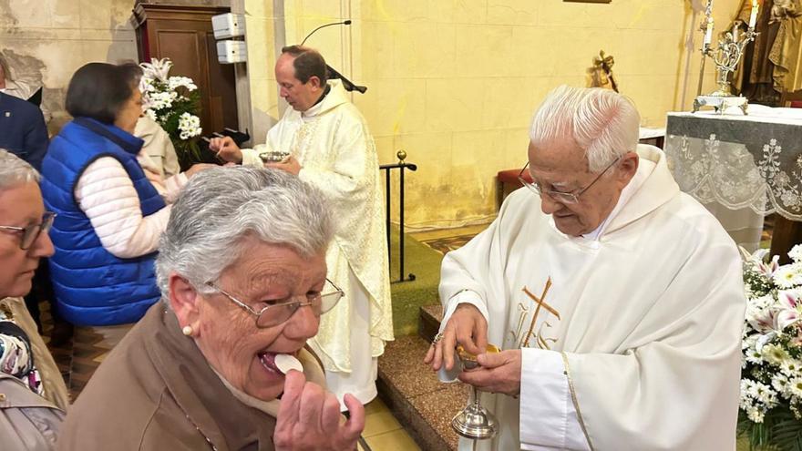 El Padre Ángel y José Antonio Alonso dan la comunión a los asistentes. | N. M.