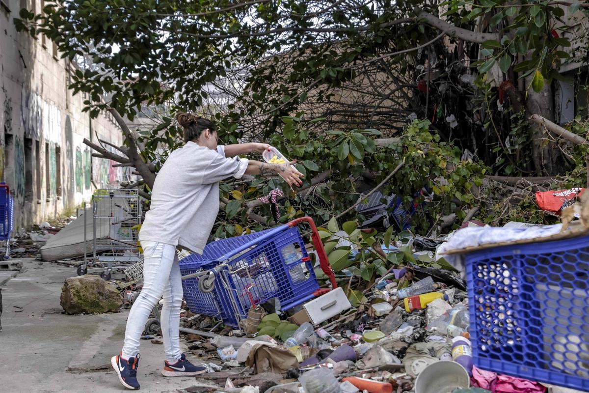 Una mujer lanza desperdicios dentro del recinto.