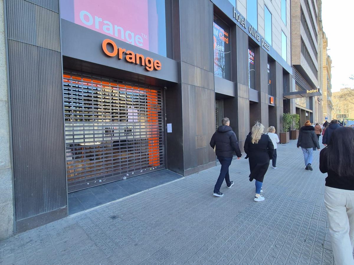 La tienda de Orange en la plaza Catalunya, en Barcelona, con la persiana bajada este jueves, a causa del viento.