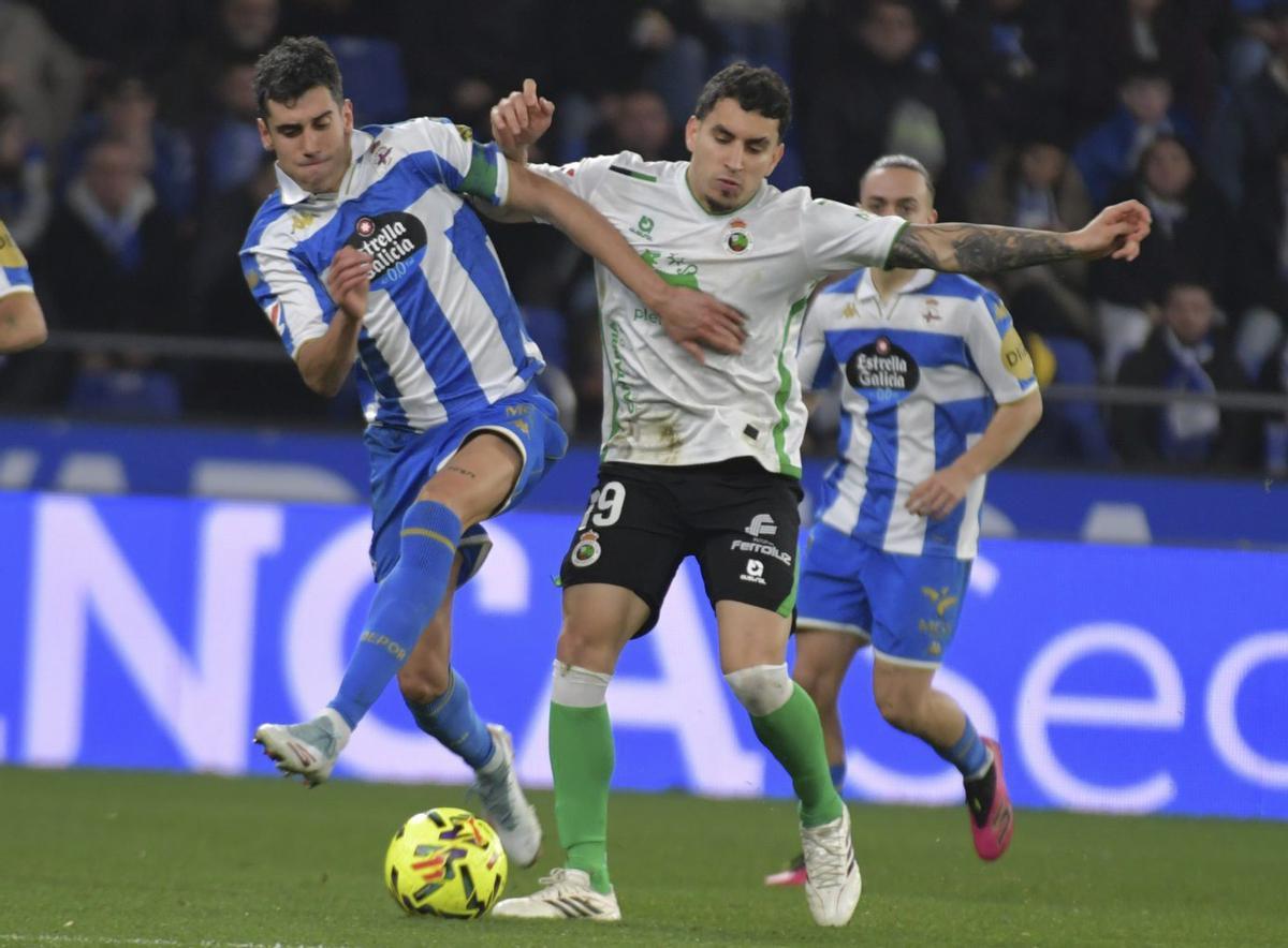 Villares disputa una pelota con Gustavo Puerta.